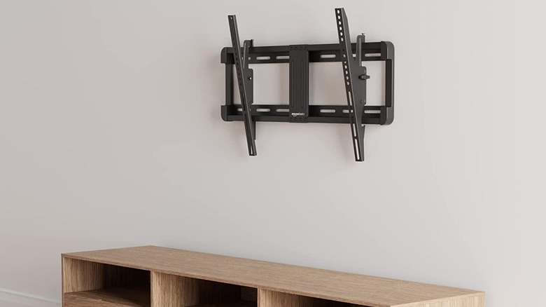 A tilting TV wall mount above a low cabinet.