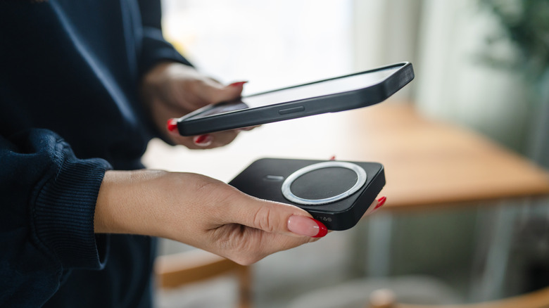 Woman holding phone and wireless magnetic power bank