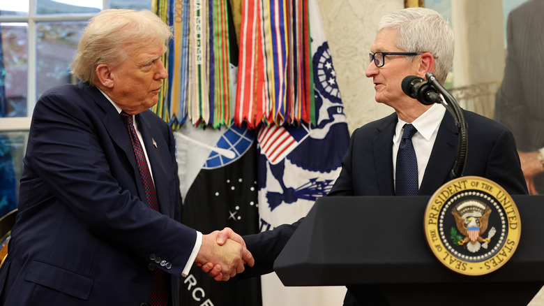 US President Donald Trump shaking Tim Cook's hand
