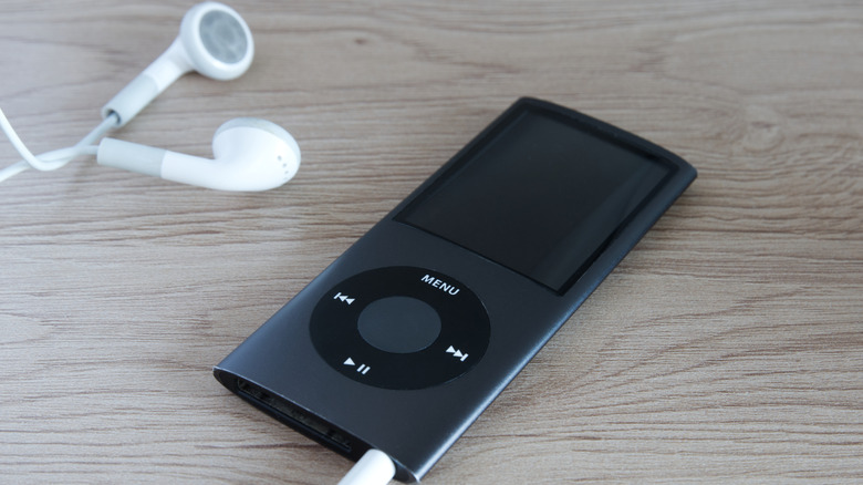 A black 4th gen iPod Nano with white old earpods