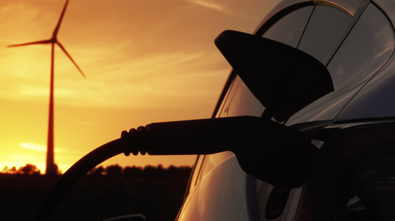 An EV being charged at sunset