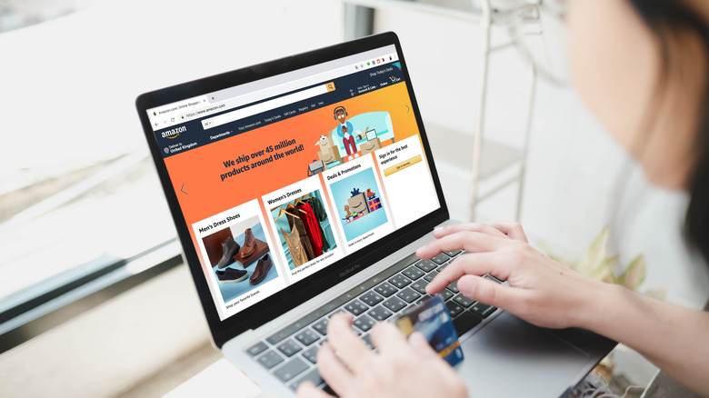 Woman on a laptop displaying the Amazon homepage