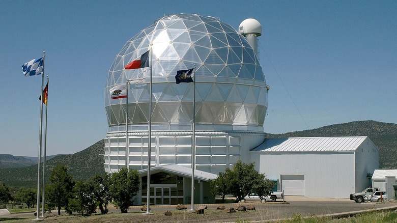 Photo of the Hobby-Eberly Telescope in Texas. A parked car on the bottom right shows the device's scale