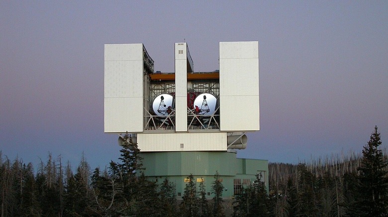 Photo of the Large Binocular Telescope, rising above the surrounding trees.