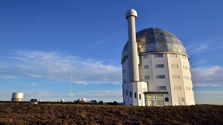 Photo of the SALT telescope in South Africa. There are clouds in the sky above the telescope