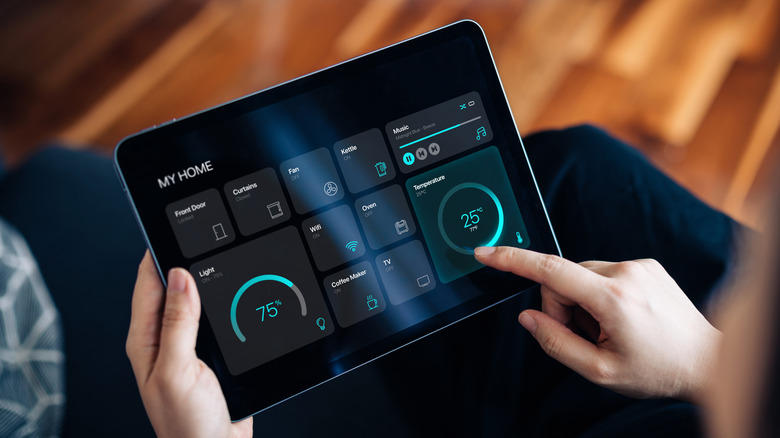 Person holding tablet device with smart home controls