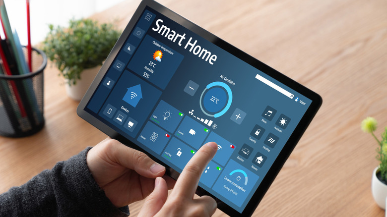 Man controlling smart home from a tablet device