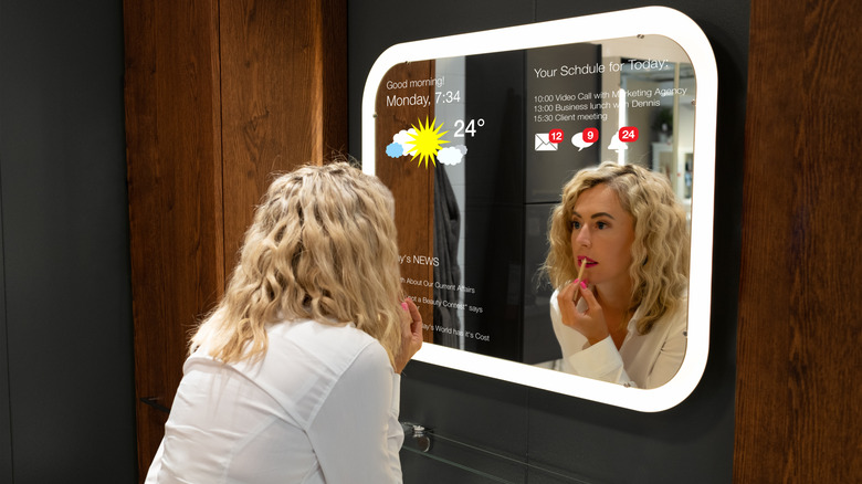 Woman in bathroom using smart mirror