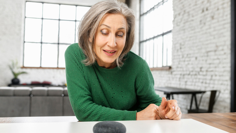 An older adult talking to a smart home hub