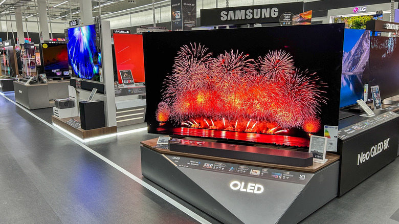 OLED TVs on display in a store showing bright fireworks.