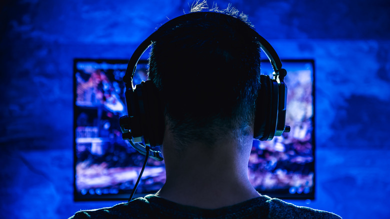 A PC gamer seen from behind wearing headphones.