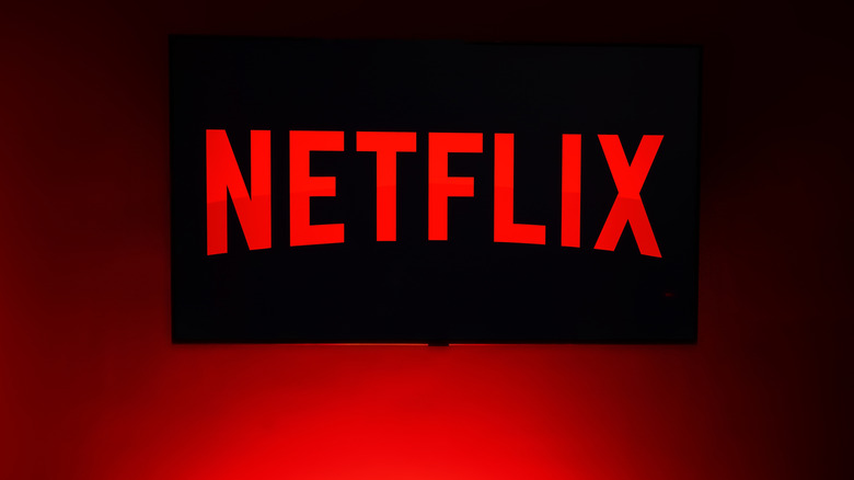 The Netflix logo on a wall-mounted TV.