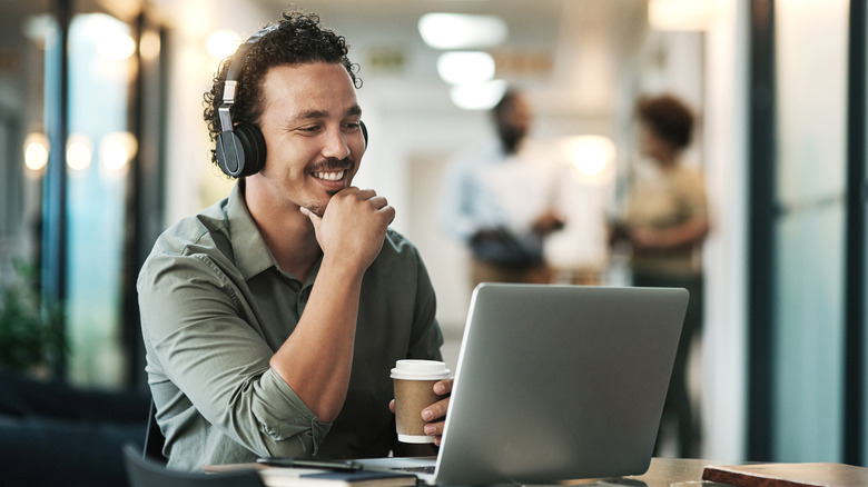 A man in an office using wireless headphones.