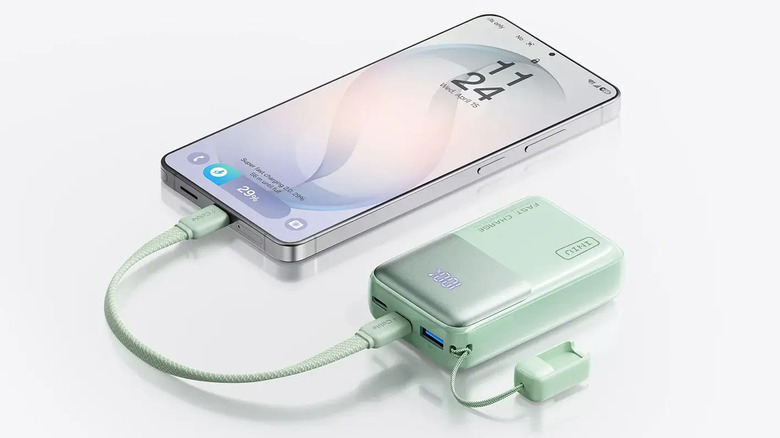 A mint green iniu p50 charging a samsung galaxy phone
