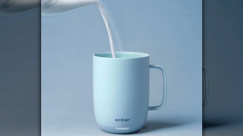 Pouring milk in a blue Ember mug