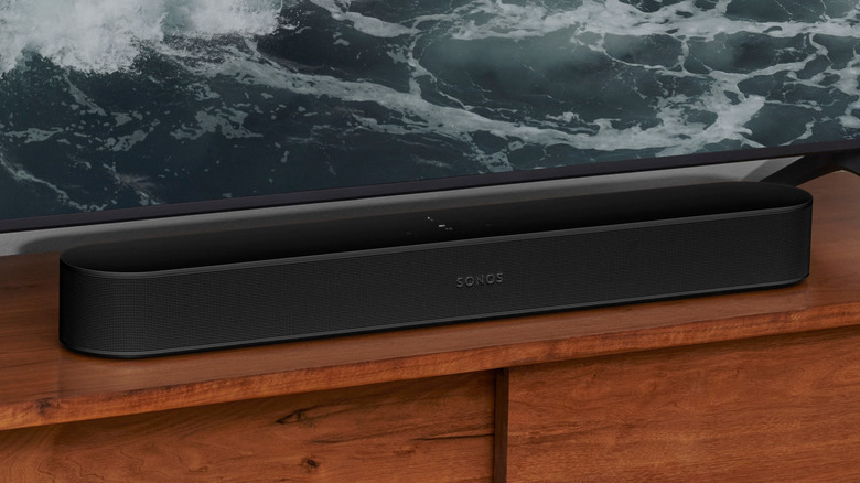 Close up of the Sonos Beam (Gen 2) sitting on a wooden table underneath a TV