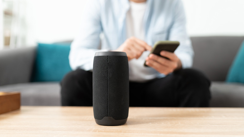 Man connecting smartphone to Bluetooth speaker