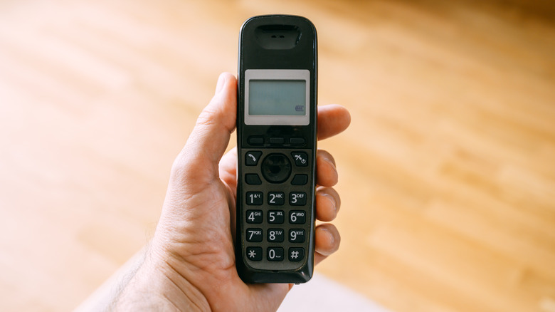 Hand holding cordless telephone