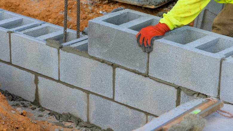 Construction worker plastering cement on brick wall