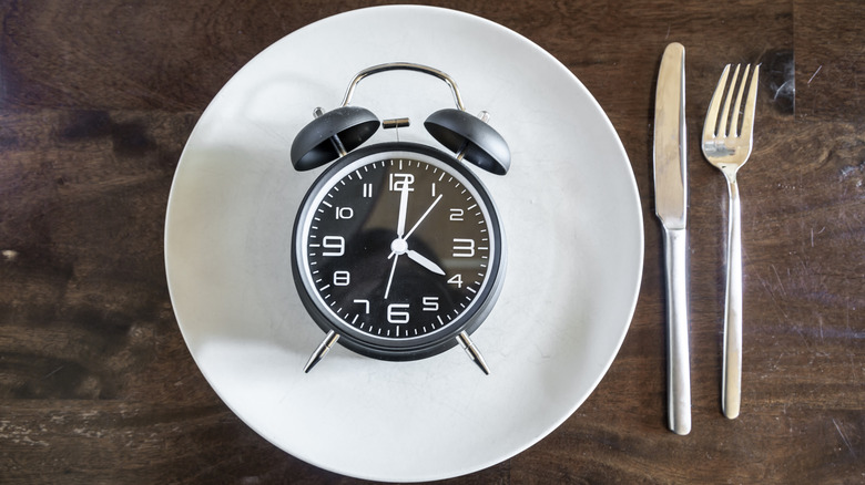 Fasting represented with clock on empty plate