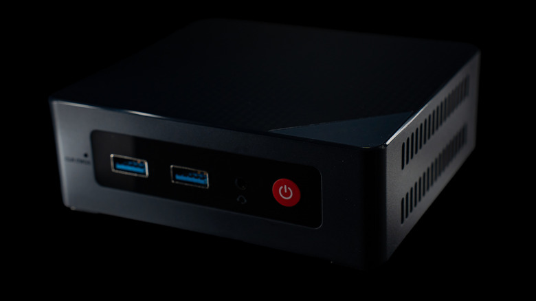 A generic mini PC with two blue USB ports visible, set against a black background.