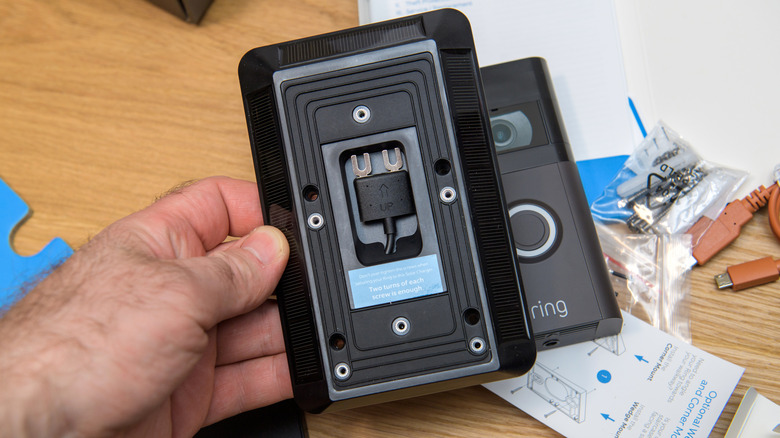 A man's hand holding Ring doorbell's solar battery