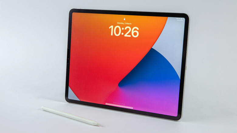 An Apple iPad Pro featuring the lock screen and an Apple Pencil against a light gray background.