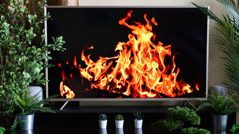 A TV set showing a wallpaper of a crackling fire.
