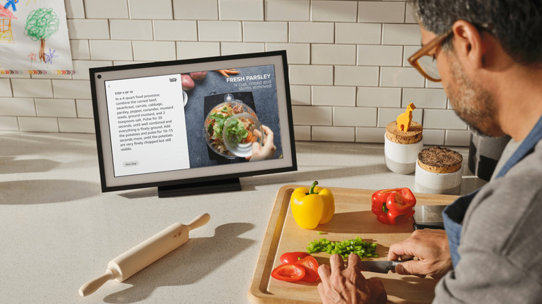 A man following a recipe on the Amazon Echo Show 15 in the kitchen.