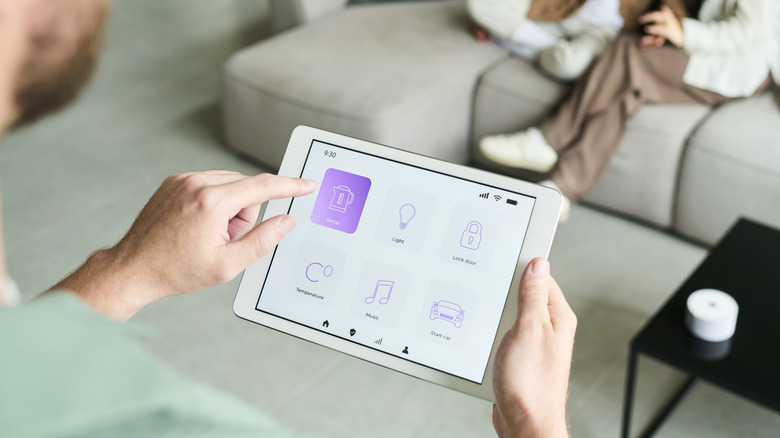 A man accessing smart home features on a tablet.