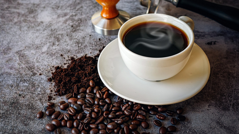 Coffee cup with beans and coffee grounds