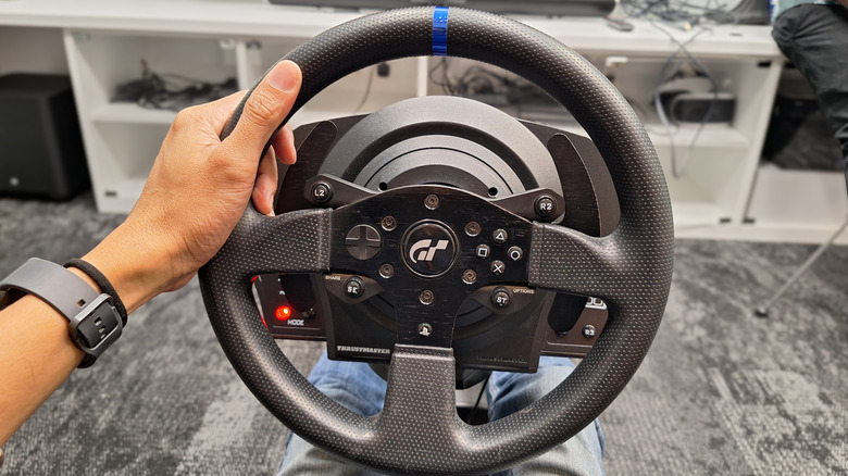 A person holding a racing simulator wheel