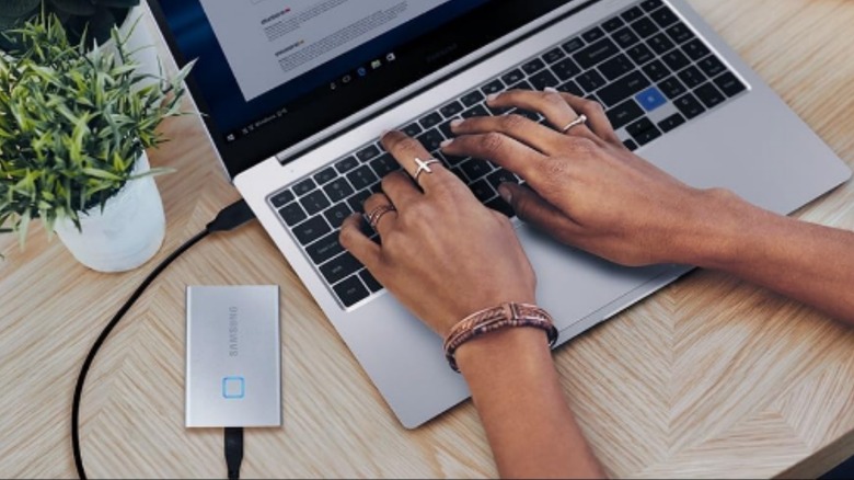 Someone using the Samsung T7 Touch Portable SSD on a laptop