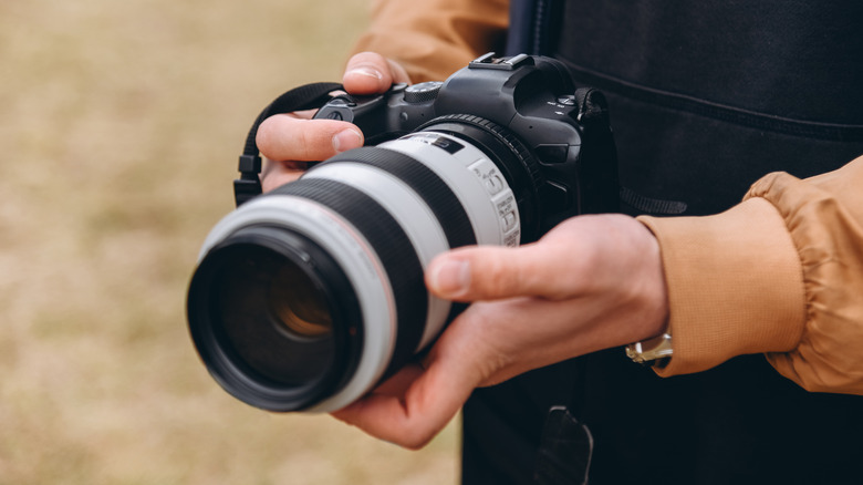A man holding a DSLR camera.