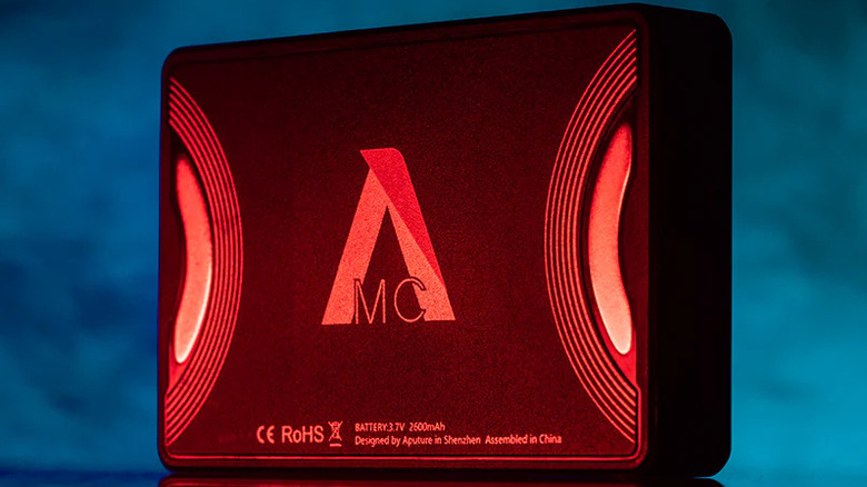 A compact LED video light glowing red against a dark blue background.