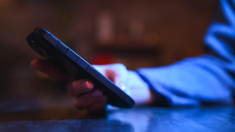 A person using their phone in a dark environment.