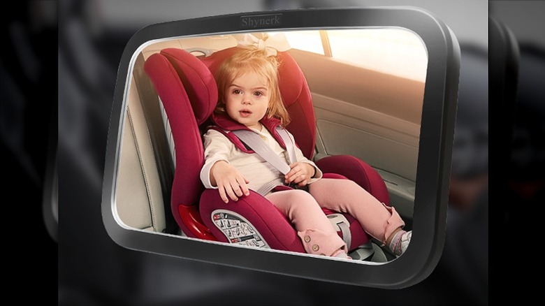 Baby girl seen in a car mirror