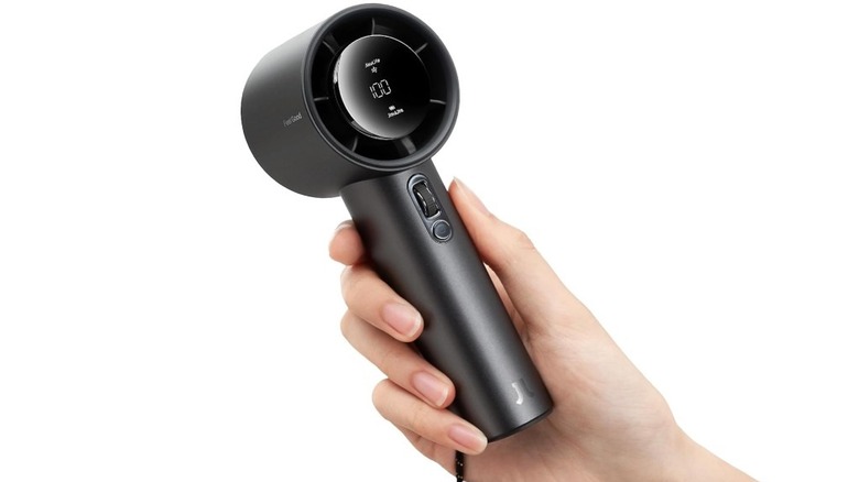 A hand holding the Jisulife Pro1S handheld fan