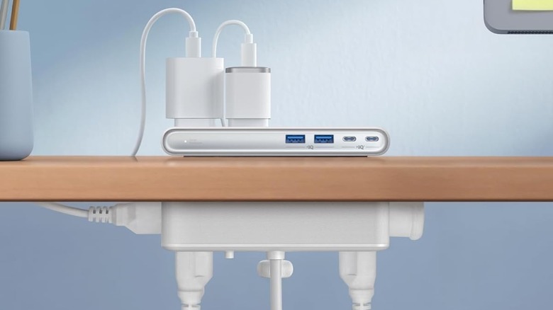 Anker Nano Power Strip attached to the side of a desk with multiple plugs in it