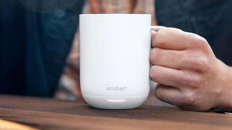 Ember Smart Mug 2 being held by a person with the logo shown