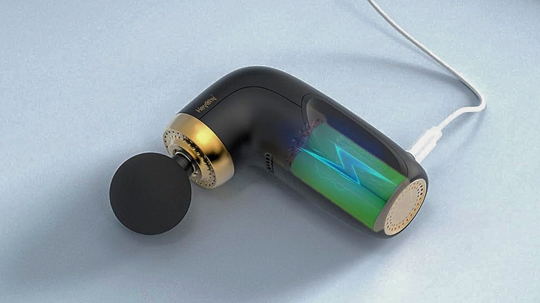 A Heychy A1 Super Mini Massage Gun charging via USB.