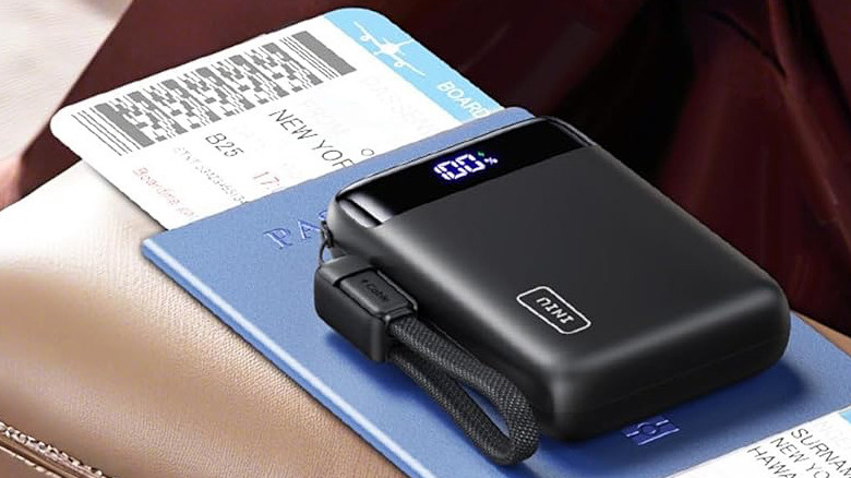 The Iniu Portable Charger resting on top of a passport and boarding pass.