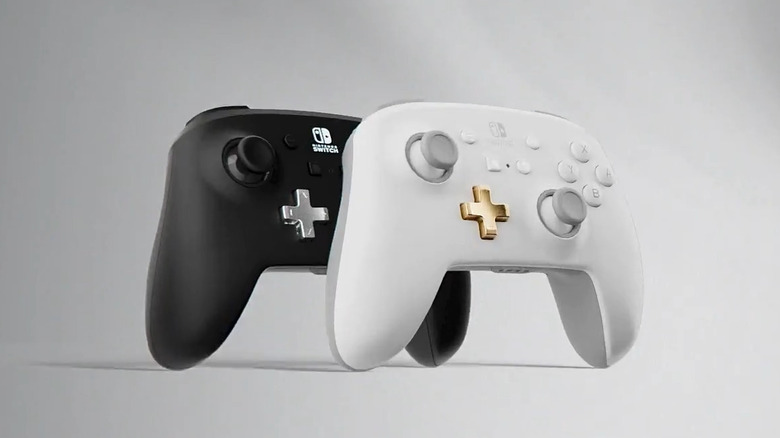 Two PowerA Enhanced wireless Nintendo Switch controllers, one black and one white, on a white-gray background.