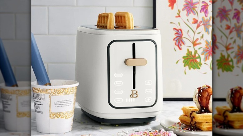 Two waffles popping out of a white toaster
