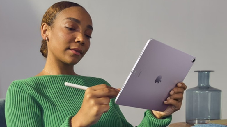 A woman using the Apple Pencil Pro digital stylus on an iPad.