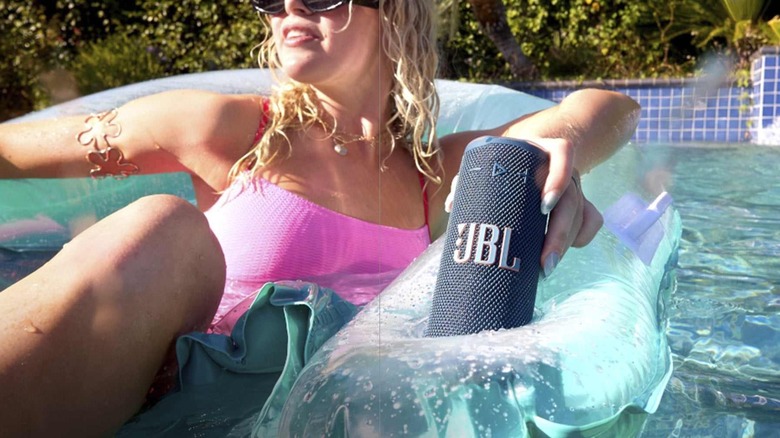 The JBL Grip being held by a woman in a pool float.