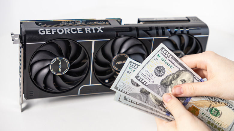 A person counts out 100 dollar bills to pay for a graphics card visible in the background.