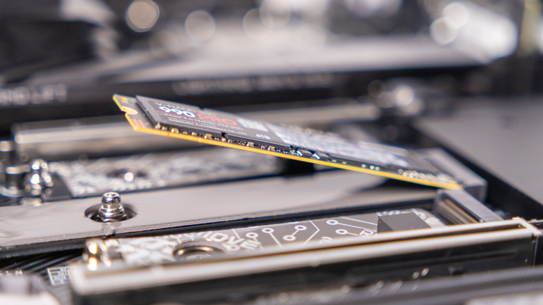 A Samsung NVMe SSD inserted in a slot on a motherboard, but not yet secured.