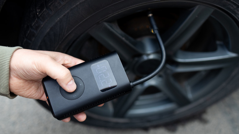 Image of a person checking their tire pressure