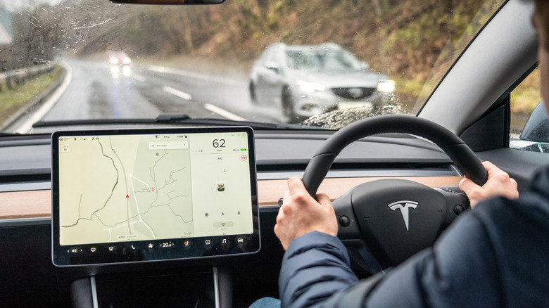 Image of a person driving an EV on a rainy road